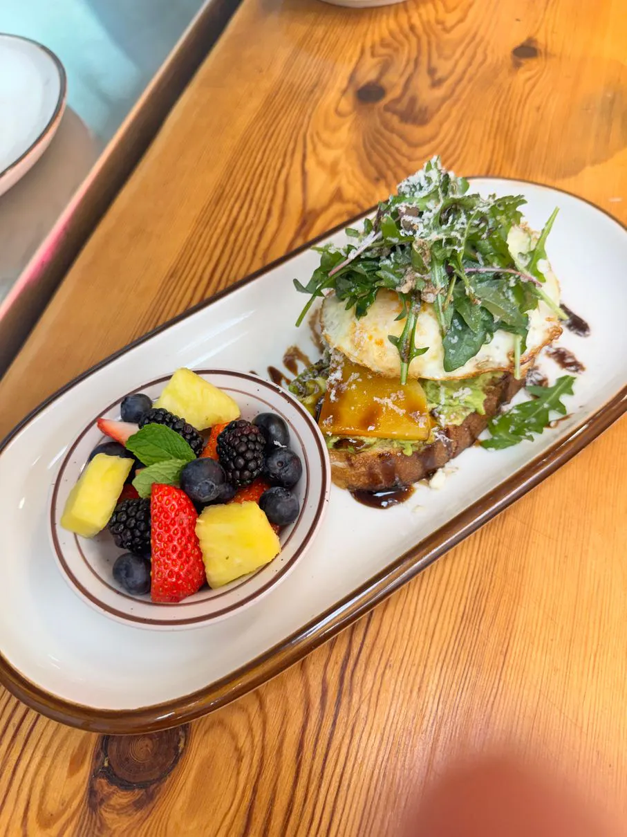 Avocado toast with fried egg and fruit at Simply Sabroso by Taqueria Rendon, a Café & Dessert Shop in Northfield